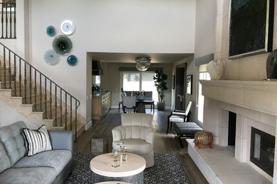 Inspiration for a large transitional formal and open concept light wood floor and brown floor living room remodel in Orange County with white walls, a standard fireplace, a tile fireplace and no tv
