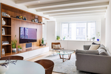 Photo of a modern living room in New York with white walls, light hardwood flooring, no fireplace and a built-in media unit.