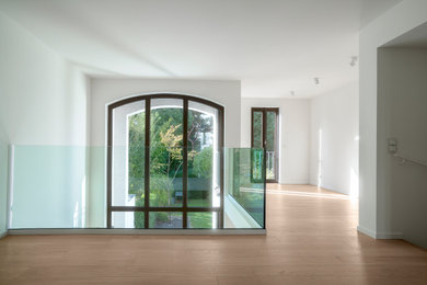Modernes Wohnzimmer mit weißer Wandfarbe und hellem Holzboden in Essen