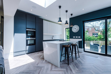 Inspiration for a large kitchen in Manchester with a built-in sink, quartz worktops, glass sheet splashback and an island.