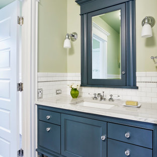 Inspiration pour une salle de bain craftsman avec un placard à porte affleurante, des portes de placard bleues, un carrelage blanc, un carrelage métro, un mur vert, un sol en carrelage de terre cuite, un lavabo encastré, un sol gris et un plan de toilette gris.