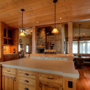 Mittelgroße Landhausstil Küche in U-Form mit Vorratsschrank, Unterbauwaschbecken, profilierten Schrankfronten, braunen Schränken, Arbeitsplatte aus Fliesen, Küchenrückwand in Beige, Rückwand aus Porzellanfliesen, Elektrogeräten mit Frontblende, braunem Holzboden, Kücheninsel, braunem Boden und beiger Arbeitsplatte in Seattle