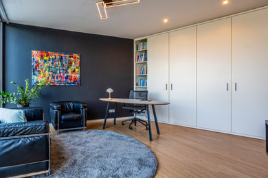 Mittelgroßes Modernes Wohnzimmer mit grauer Wandfarbe, braunem Holzboden und Steinwänden in Düsseldorf