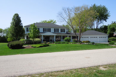 Inspiration for a large timeless white two-story vinyl house exterior remodel in Chicago with a hip roof and a shingle roof