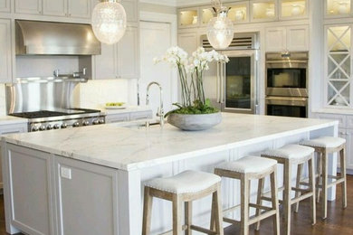 Inspiration for a large contemporary l-shaped medium tone wood floor and brown floor open concept kitchen remodel in Phoenix with a farmhouse sink, shaker cabinets, white cabinets, marble countertops, white backsplash, stainless steel appliances, an island and white countertops