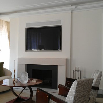 Flat mounted TV in niche above fireplace. Grilled speaker above.