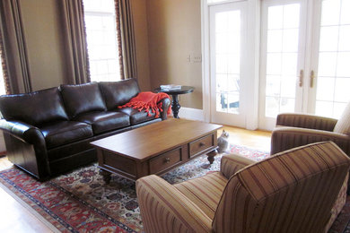 Example of a mid-sized classic open concept medium tone wood floor living room design in Other with brown walls, no fireplace and no tv