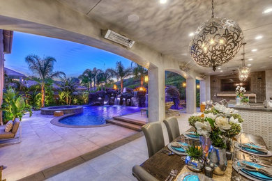 Huge tuscan backyard concrete paver patio photo in Orange County with a fire pit and no cover