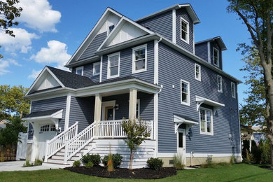 Inspiration for a large traditional three-storey blue exterior in New York with vinyl siding and a gable roof.