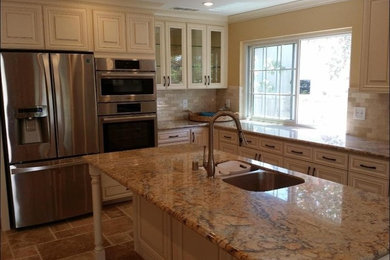 Eat-in kitchen photo in Phoenix with glass-front cabinets, white cabinets, granite countertops and an island