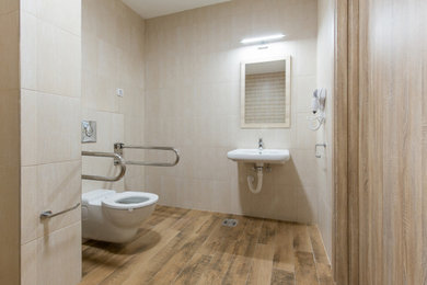 Mid-sized minimalist beige tile and ceramic tile ceramic tile and brown floor powder room photo in Los Angeles with a wall-mount toilet, beige walls, a wall-mount sink, concrete countertops and white countertops