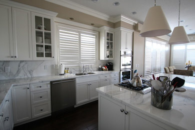 Elegant l-shaped dark wood floor eat-in kitchen photo in Minneapolis with an undermount sink, white cabinets, marble countertops, white backsplash, stone slab backsplash, stainless steel appliances, shaker cabinets and an island