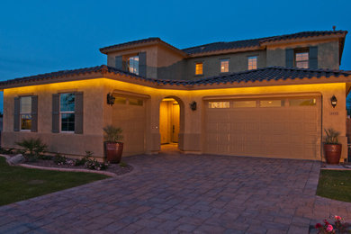 Inspiration for a large mediterranean beige two-story stucco exterior home remodel in Phoenix