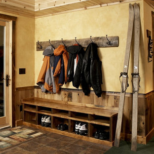 Immagine di un ingresso o corridoio stile rurale con pareti gialle e pavimento in gres porcellanato