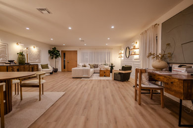 Family room - contemporary open concept light wood floor and wainscoting family room idea in Los Angeles with beige walls, a standard fireplace, a plaster fireplace and a media wall