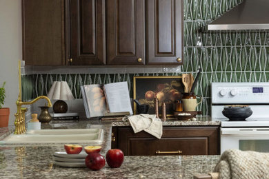 Example of a large arts and crafts light wood floor kitchen design in Seattle with a drop-in sink, raised-panel cabinets, dark wood cabinets, granite countertops, green backsplash, glass tile backsplash, stainless steel appliances and brown countertops