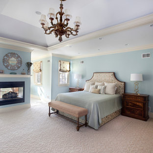 Inspiration för ett stort vintage huvudsovrum, med blå väggar, heltäckningsmatta, en dubbelsidig öppen spis och beiget golv
