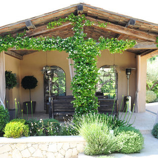 マルセイユの中サイズの地中海スタイルのおしゃれな裏庭のテラス (天然石敷き、張り出し屋根、壁面緑化) の写真