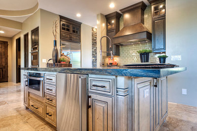 Open concept kitchen - large rustic open concept kitchen idea in Phoenix with shaker cabinets, distressed cabinets, marble countertops, green backsplash, subway tile backsplash, stainless steel appliances and an island