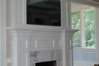 This is an example of a mid-sized transitional enclosed family room in Newark with beige walls, carpet, a standard fireplace, a built-in media wall and a tile fireplace surround.