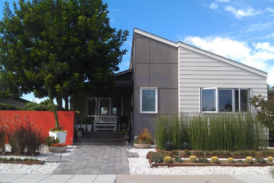 Inspiration for a mid-sized contemporary gray one-story mixed siding flat roof remodel in San Diego
