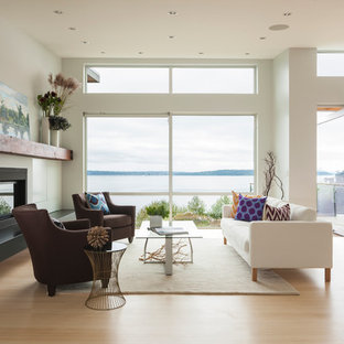 Idéer för mellanstora funkis allrum med öppen planlösning, med ett finrum, vita väggar, ljust trägolv, en standard öppen spis, en spiselkrans i metall och beiget golv