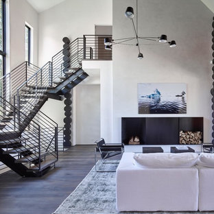 Idéer för ett modernt vardagsrum, med vita väggar, mörkt trägolv, en öppen vedspis och en spiselkrans i metall