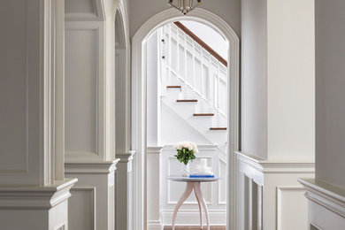 Hallway - traditional medium tone wood floor and brown floor hallway idea in New York with white walls