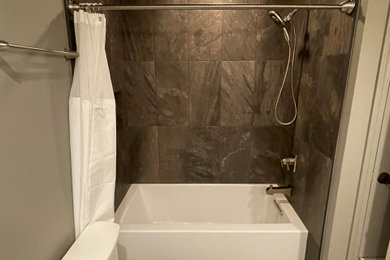 Example of a mid-sized trendy kids' brown tile and porcelain tile porcelain tile, gray floor and single-sink bathroom design in Austin with recessed-panel cabinets, white cabinets, a two-piece toilet, gray walls, an undermount sink, granite countertops, black countertops, a niche and a built-in vanity