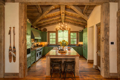 Inspiration for a rustic u-shaped medium tone wood floor kitchen remodel in Denver with recessed-panel cabinets, green cabinets, wood countertops, paneled appliances, a farmhouse sink and an island