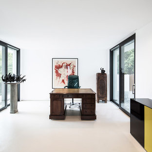 Large modern study in Stuttgart with white walls, a freestanding desk, vinyl flooring and white floors.
