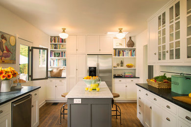 Kitchen - traditional u-shaped kitchen idea in Santa Barbara with glass-front cabinets, white cabinets, soapstone countertops, white backsplash, subway tile backsplash and stainless steel appliances