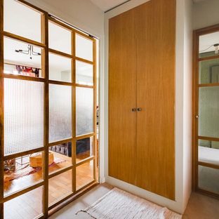 Eklektisk inredning av en liten foajé, med gröna väggar, en skjutdörr och ljus trädörr