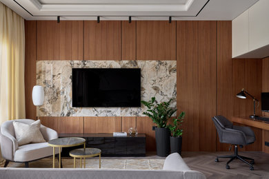 Идея дизайна: гостиная комната в современном стиле с полом из ламината, телевизором на стене, панелями на части стены и ковром на полу