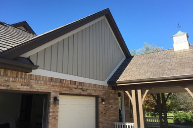 Large elegant beige two-story concrete fiberboard exterior home photo in Chicago with a gambrel roof