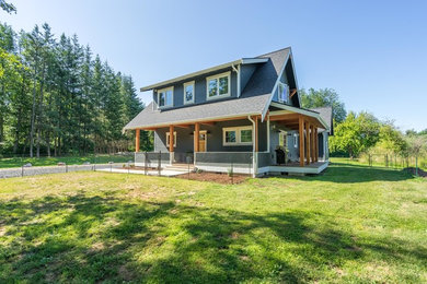 Example of a mid-sized arts and crafts gray two-story wood exterior home design in Seattle with a shingle roof