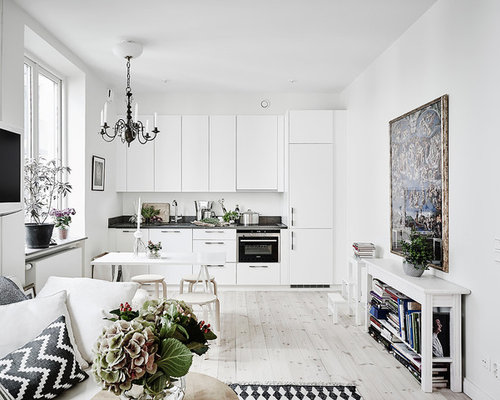 Idéer för små skandinaviska linjära kök och matrum, med släta luckor, vita skåp, granitbänkskiva, ljust trägolv och rostfria vitvaror