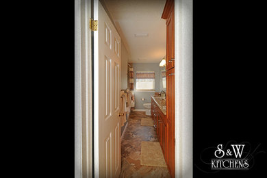 Tub/shower combo - mid-sized traditional beige tile slate floor tub/shower combo idea in Orlando with an undermount sink, raised-panel cabinets, medium tone wood cabinets, granite countertops and blue walls