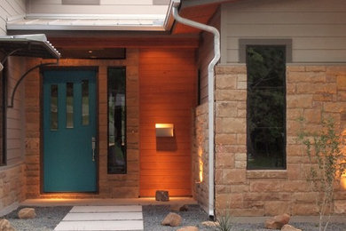 Photo of a modern two-storey exterior in Austin with mixed siding.