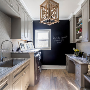 Design ideas for a medium sized traditional galley utility room in Charlotte with a submerged sink, recessed-panel cabinets, grey cabinets, marble worktops, dark hardwood flooring, a side by side washer and dryer and black walls.
