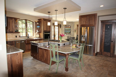 Open concept kitchen - huge eclectic l-shaped porcelain tile open concept kitchen idea in Denver with a farmhouse sink, shaker cabinets, medium tone wood cabinets, granite countertops, beige backsplash, stone tile backsplash, stainless steel appliances and an island