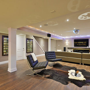 Ejemplo de sótano con ventanas contemporáneo, grande, con paredes grises, suelo laminado y chimenea tradicional