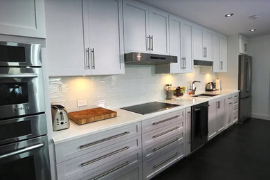 Large trendy galley porcelain tile and gray floor eat-in kitchen photo in Other with a double-bowl sink, shaker cabinets, white cabinets, quartzite countertops, white backsplash, porcelain backsplash, stainless steel appliances, an island and white countertops