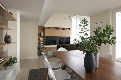 Example of a mid-sized trendy vinyl floor and gray floor kitchen/dining room combo design in Seattle with beige walls, a wood fireplace surround and no fireplace