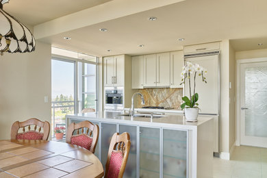 Eat-in kitchen - mid-sized eclectic galley porcelain tile and beige floor eat-in kitchen idea in Vancouver with a double-bowl sink, shaker cabinets, beige cabinets, solid surface countertops, brown backsplash, granite backsplash, paneled appliances, an island and white countertops