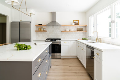 Mid-sized transitional light wood floor and beige floor eat-in kitchen photo in New York with an undermount sink, shaker cabinets, gray cabinets, quartz countertops, white backsplash, ceramic backsplash, stainless steel appliances, an island and multicolored countertops