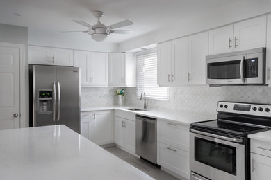 Example of a mid-sized trendy l-shaped porcelain tile and multicolored floor eat-in kitchen design in Toronto with a double-bowl sink, shaker cabinets, white cabinets, quartz countertops, multicolored backsplash, marble backsplash, stainless steel appliances and an island