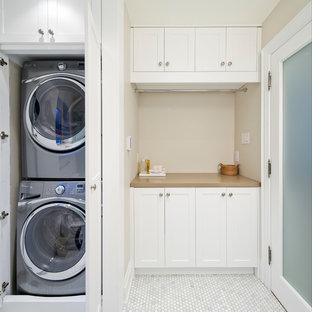 Design ideas for a small traditional single-wall utility room in Toronto with beige walls, white cabinets, shaker cabinets, engineered stone countertops, marble flooring, a stacked washer and dryer, white floors and beige worktops.