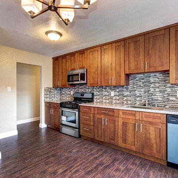 Warm Wood Kitchen with Full-Height Cabinetry and Mosaic Backsplash