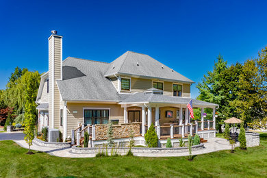 Example of a large transitional backyard mixed material railing deck design in Other with a roof extension